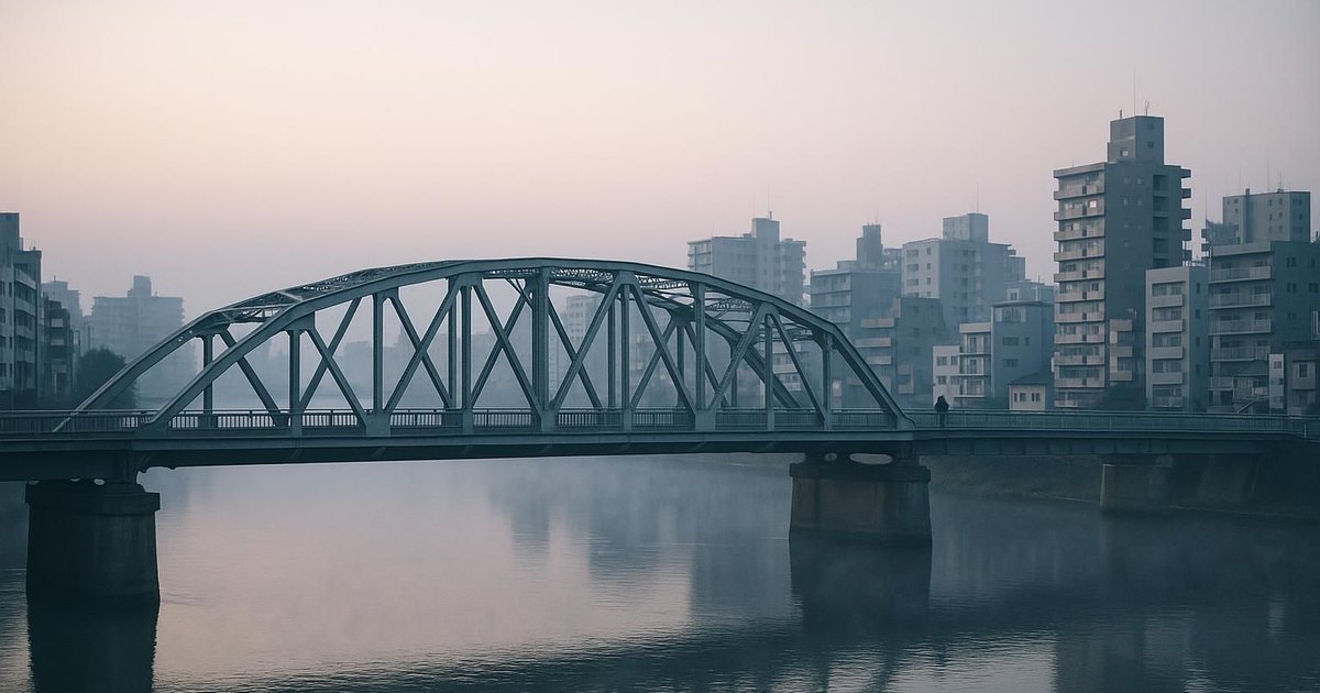 A steel bridge over a river in a Japanese city at dawn